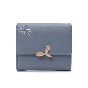 Detail of grey-blue leather wallet showing delicate leaf embroidery and golden buckle