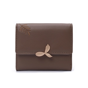 Detail of dark brown leather wallet featuring leaf embroidery and golden leaf metal clasp