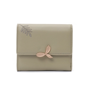 Close-up of sage green tri-fold wallet with leaf embroidery and rose gold clasp
