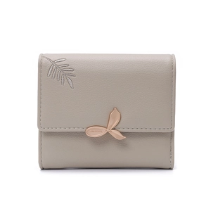 Close-up of taupe litchi grain leather wallet with silver leaf embroidery and gold buckle