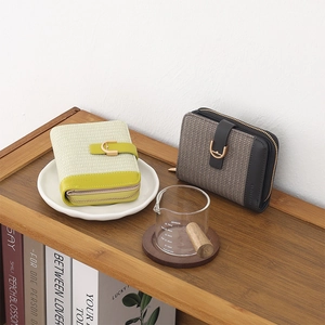 Close-up of PU leather folded wallets with woven texture and gold U-shaped metal buckle
