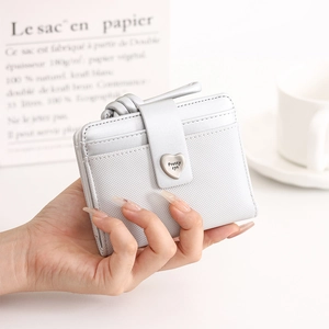 Close-up of compact bi-fold wallet featuring heart buckle and multiple card slots