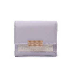Detail of lavender trifold wallet with pebble leather texture and gold metal plaque