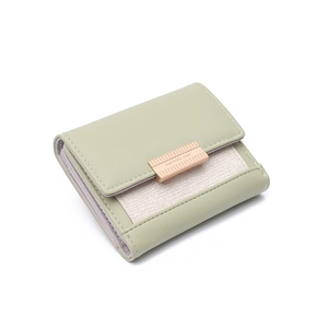 Detail of light green tri-fold faux leather wallet with woven texture and rose gold clasp