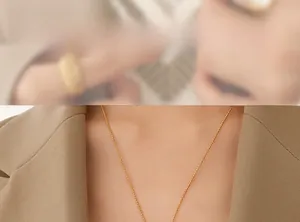 Gros plan d'un collier chaîne à billes dorées en acier titane plaqué or 18 carats