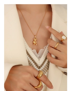 Détail du collier avec pendentif ours plaqué or 18K et bagues sur un mannequin