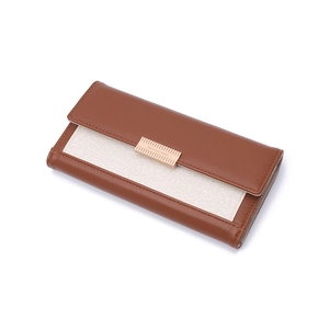 Detail of long brown wallet featuring textured leather, fabric stitching, and gold buckle