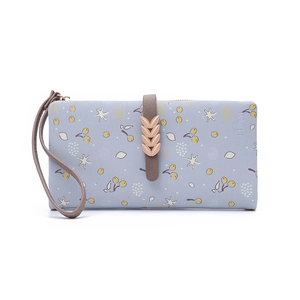 Detail of light blue floral wallet featuring golden leaf clasp and leather wrist strap
