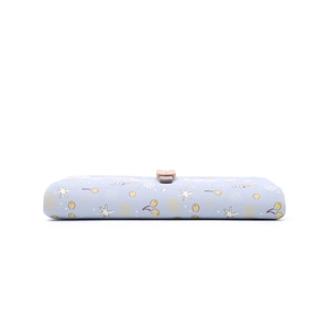 Detail of light blue floral wallet featuring yellow fruit and starfish patterns with clasp