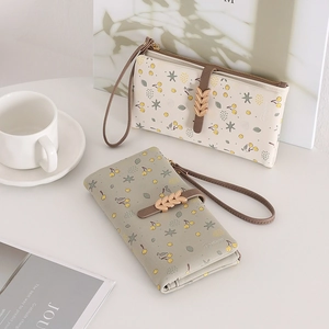 Detail of floral women's long wallet with cherry patterns and metal leaf buckle