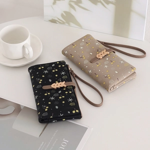 Close-up of PU leather long wallets with cherry prints and golden leaf metal buckles