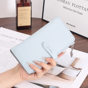 Close-up of light blue leather long wallet featuring leaf-shaped zipper and buckle strap