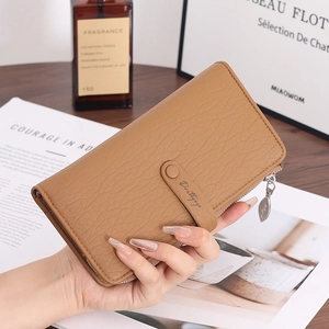 Detail of khaki pebbled leather wallet featuring a leaf-shaped metal zipper pull charm