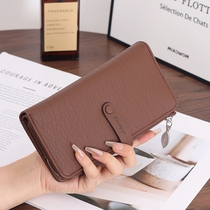 Close-up of brown faux leather wallet showing lychee texture and leaf metal zipper puller
