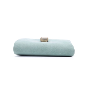 Detail view of the soft light green faux leather texture and buckle on the wallet
