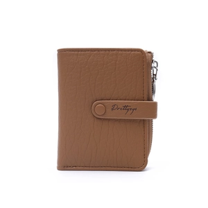 Detailed view of brown leather wallet with litchi texture and branded snap closure