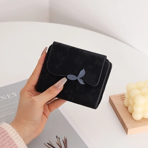 Close-up of black matte PU leather wallet with elegant leaf-shaped buckle detail