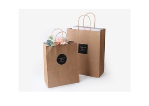 Detailed view of natural brown kraft paper gift bags with black 'Thank You' stickers
