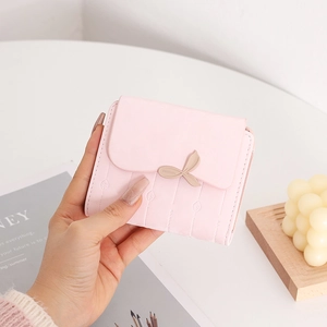Dettaglio di un piccolo portafoglio in pelle PU rosa con fibbia a foglia d'oro e trapuntatura