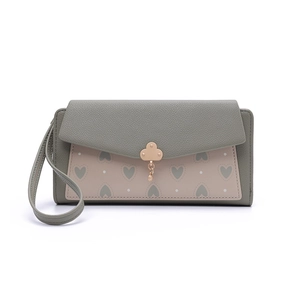 Détail du portefeuille bicolore vert gris et rose avec imprimé cœur et fermoir trèfle