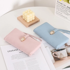 Detail of elegant PU leather long wallet with wrist strap and metal buckle closure