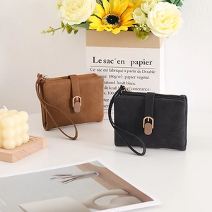 Detail of compact zip wallets in brown and black PU leather with wrist straps
