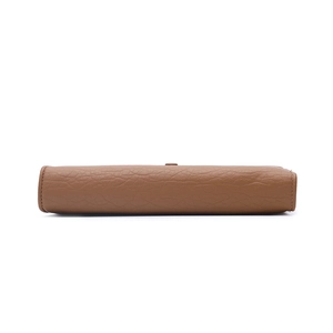 Detail of fine stitching and brown lychee grain texture on a long wallet for women