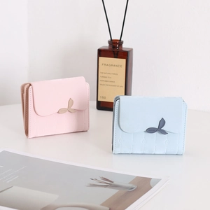 Dettaglio di portafogli in pelle PU rosa e blu con fibbia a foglia e cuciture verticali