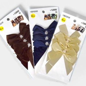 Close-up of double-layer satin gift bows in brown, blue, and beige with twist ties