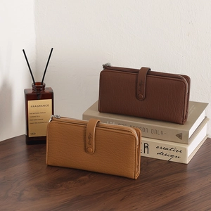 Close-up of long zip wallets in brown and tan colors with soft litchi texture finish