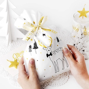 Sacchetto regalo di Natale bianco con pois dorati e cervo con nastro stampato incluso