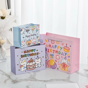 Three cute cartoon bunny and bear birthday paper gift bags in pink, blue, and purple set
