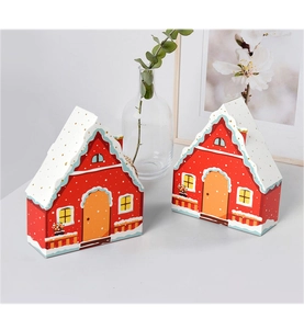 Macro detail of red and white house-shaped gift boxes with snow-capped roof on a desk