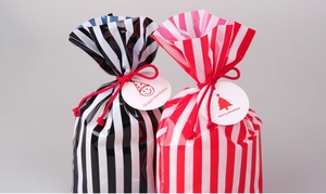 Detail of striped food gift bags with red cotton ropes and holiday gift tags