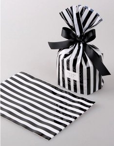 Detail of black and white striped gift bag with THANK YOU sticker and silk ribbon