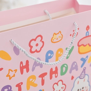 Detail of pink birthday gift bag with cute cartoon cat and Happy Birthday print