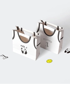 Dettaglio di sacchetti regalo panda a forma di maglia con manici fustellati e No.1