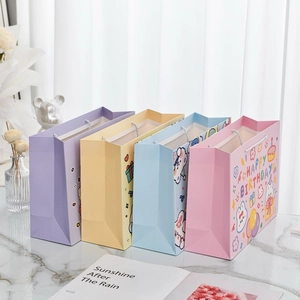 Detailed view of four colorful cartoon rabbit gift bags with white rope handles and birthday patterns