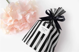 Close-up of black and white striped gift bag with silk bow and Thank You label