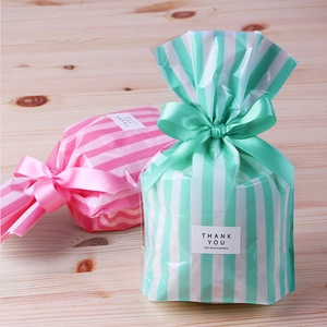 Pink and mint striped treat bags with satin bows and Thank You labels for party favors