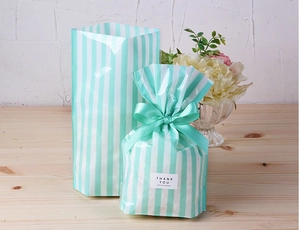 Detail of mint green striped packaging bag with Thank You sticker and ribbon bow