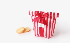 Close-up of red and white striped gift packaging bag with a satin ribbon and Thank You sticker