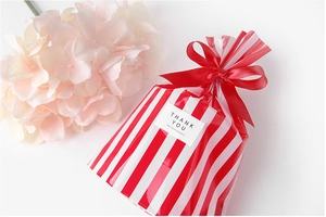 Detail of red and white striped food packaging bag with ribbon bow and thank you label