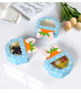 Close-up of rabbit candy boxes with clear windows and carrot toppers for party favors