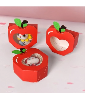 Detail of apple-shaped red gift boxes with heart window and cute plush toys inside
