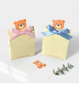 Detail of yellow gift box set with cartoon bear inserts and silk ribbon bows
