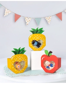 Detailed view of colorful fruit-shaped candy boxes with heart windows and leaf toppers
