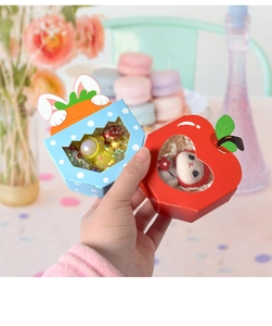 Detail of blue bunny and red apple gift boxes with transparent windows for party favors