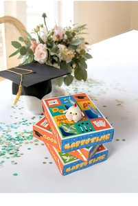 Three-tier red and blue graduation gift boxes with a plush pendant and school accessories