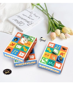 Detail of graduation gift boxes with grid patterns, academic motifs and plush chick toy
